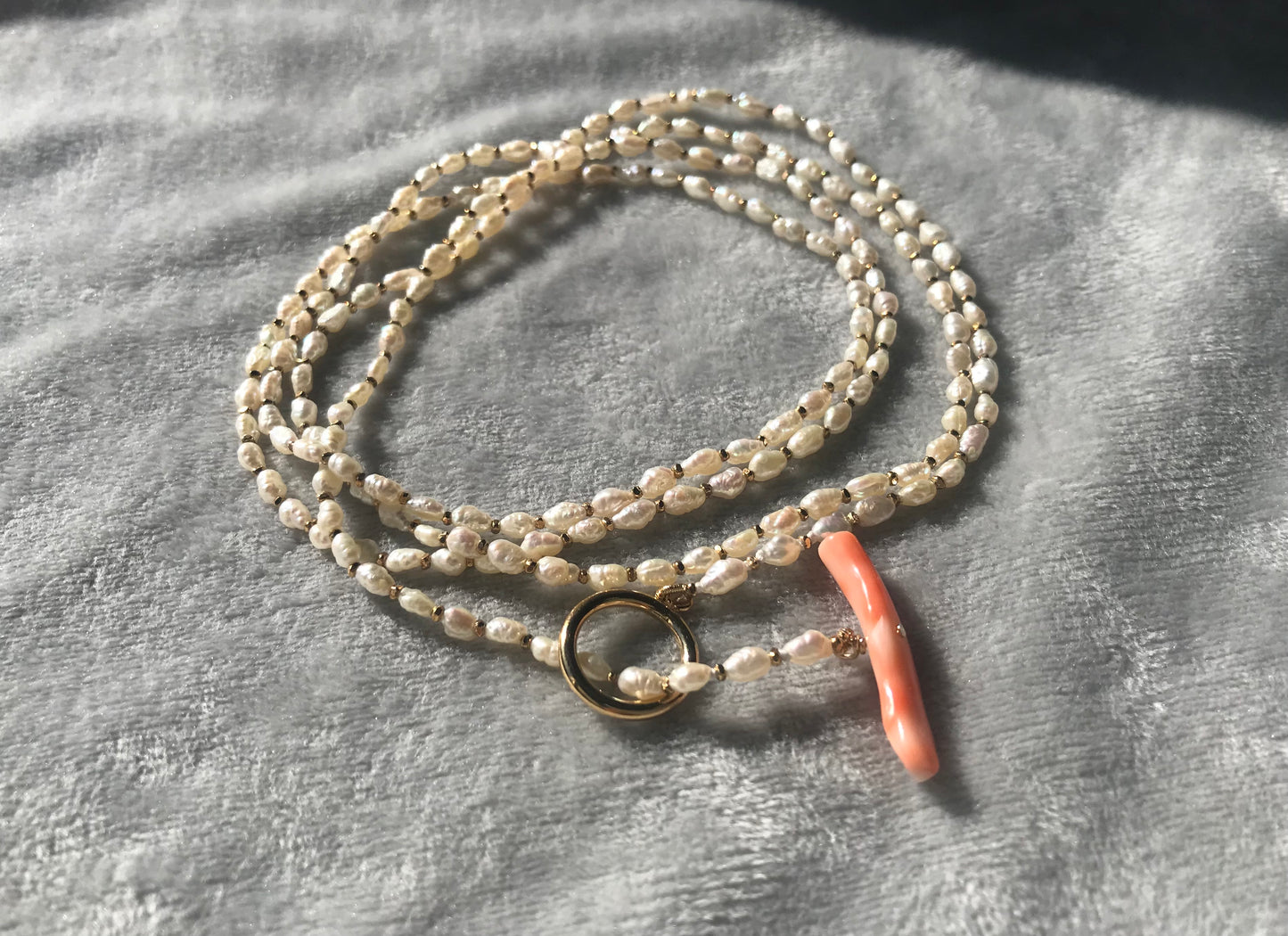 Freshwater pearl necklace with large pink coral bar