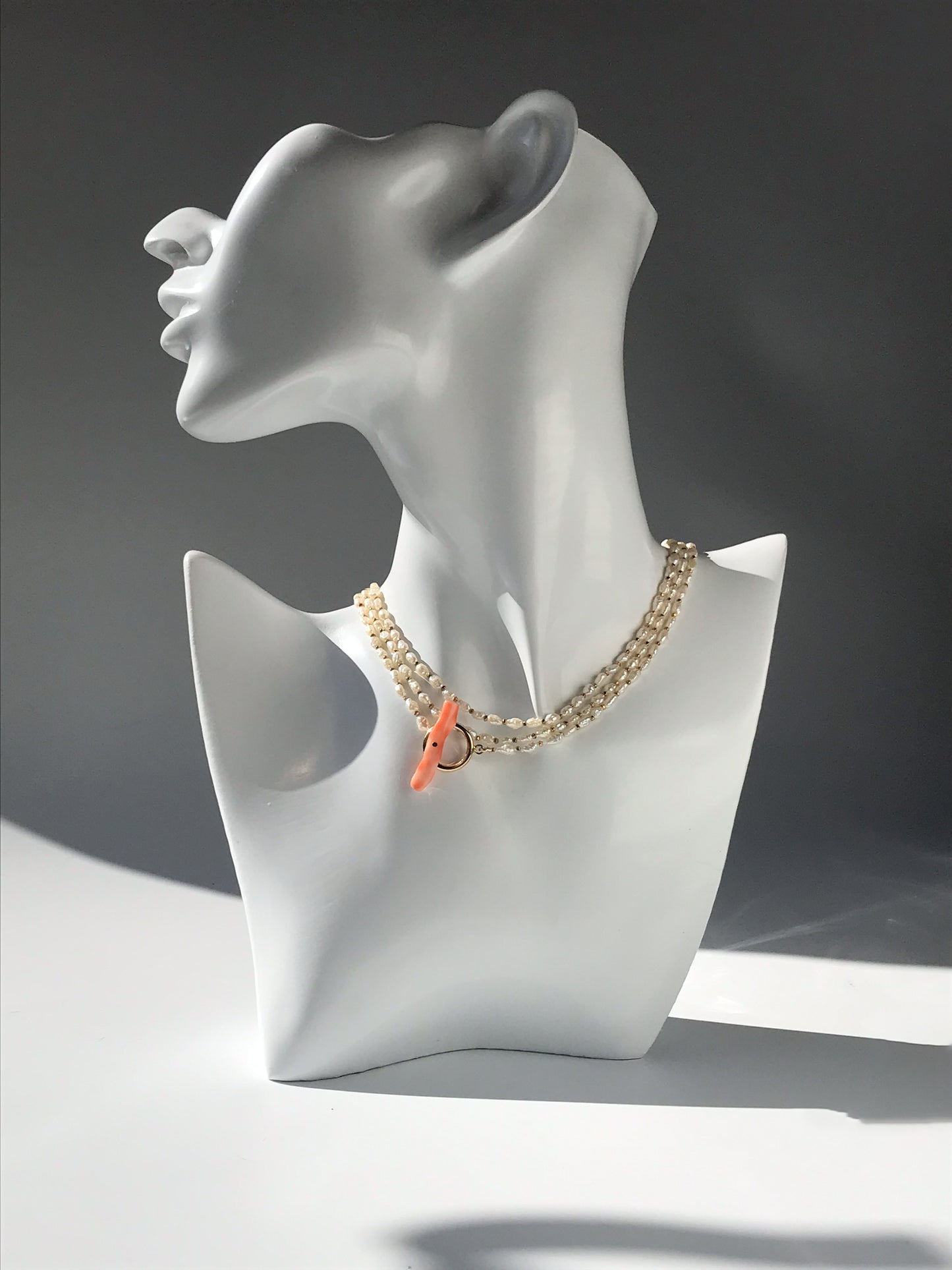 Freshwater pearl necklace with large pink coral bar
