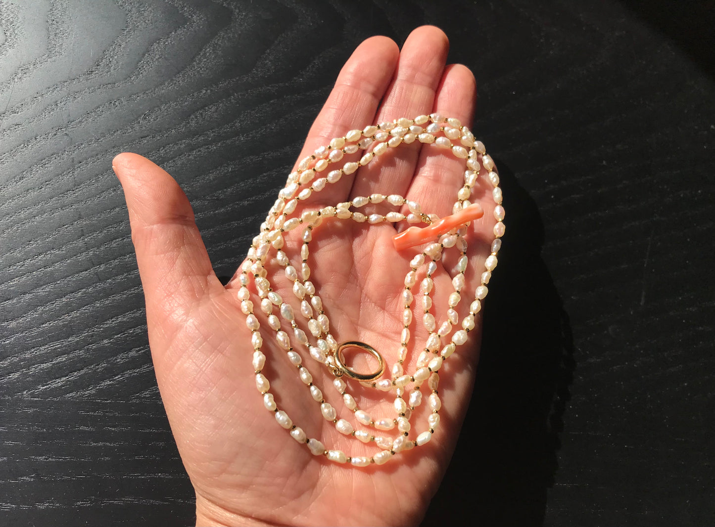 Freshwater pearl necklace with large pink coral bar
