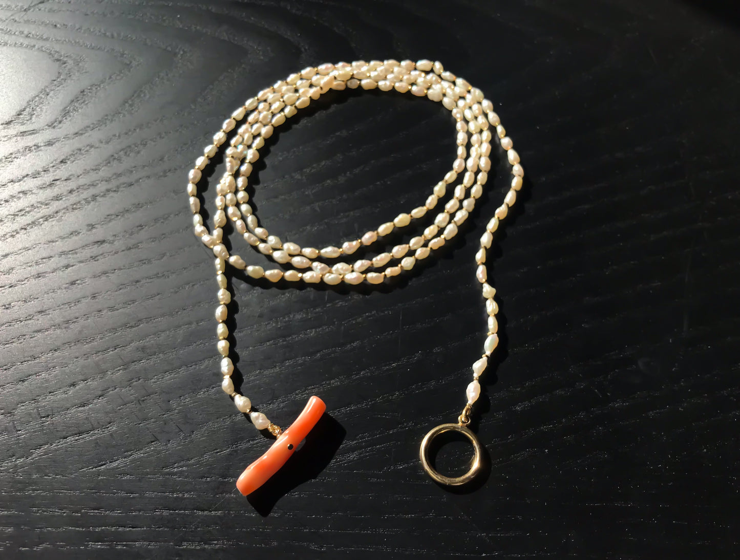 Freshwater pearl necklace with large pink coral bar