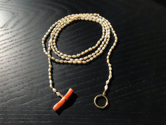 Freshwater pearl necklace with large pink coral bar