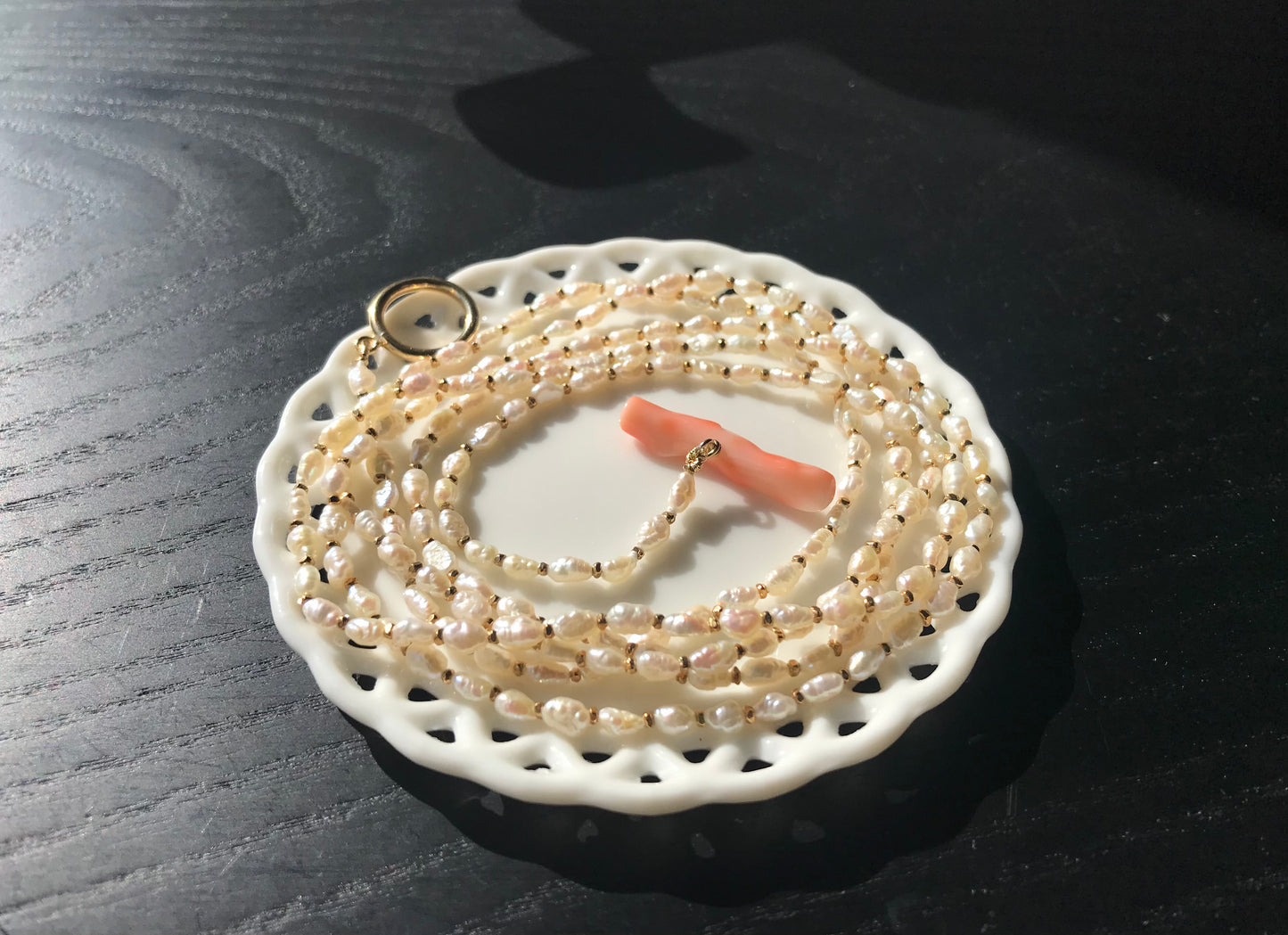 Freshwater pearl necklace with large pink coral bar