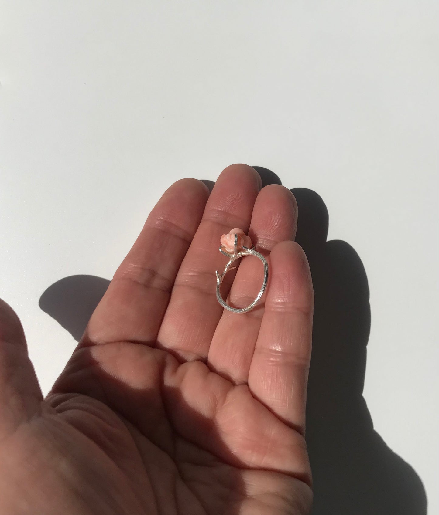 Carved angel skin coral rose ring with silver thorns